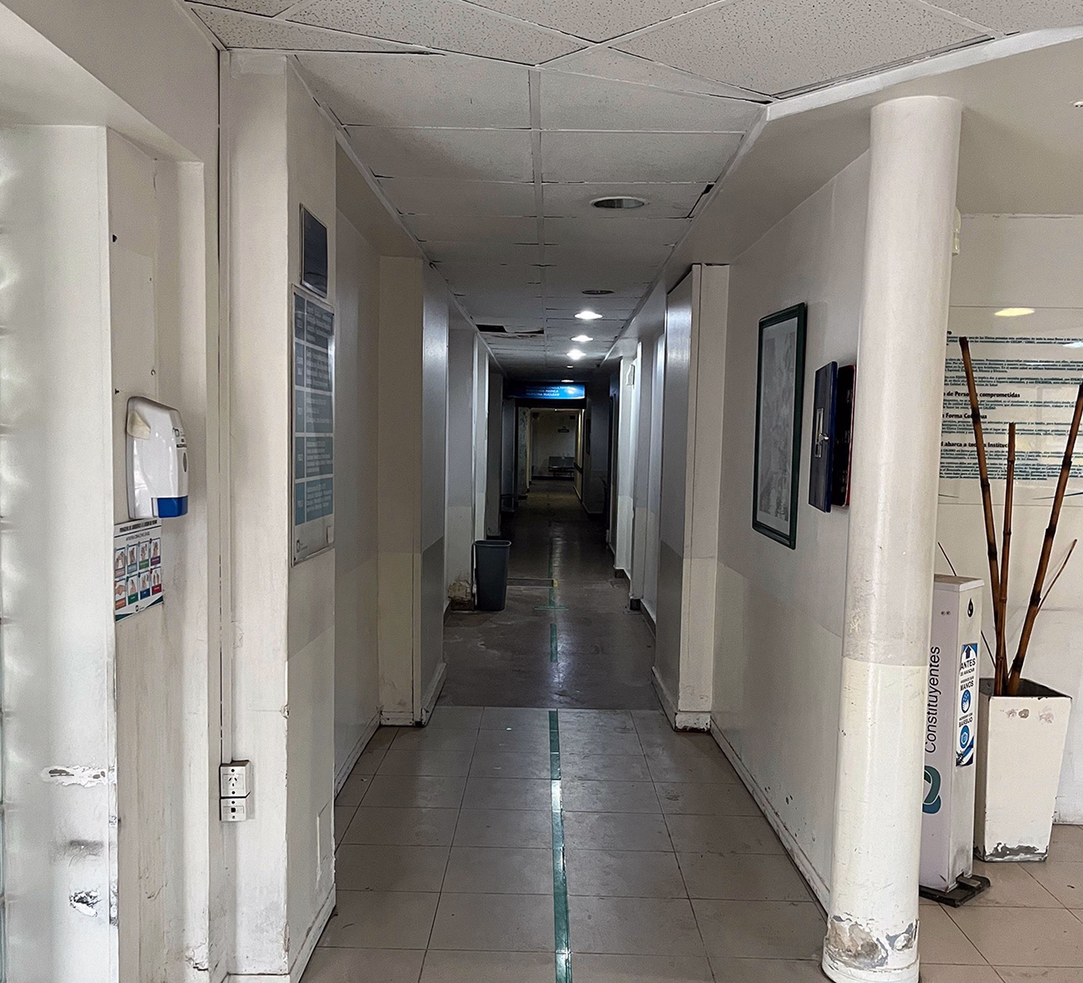 Pasillo de la Clínica Santa Clara antes de la reforma, con solado viejo y señalética suelta