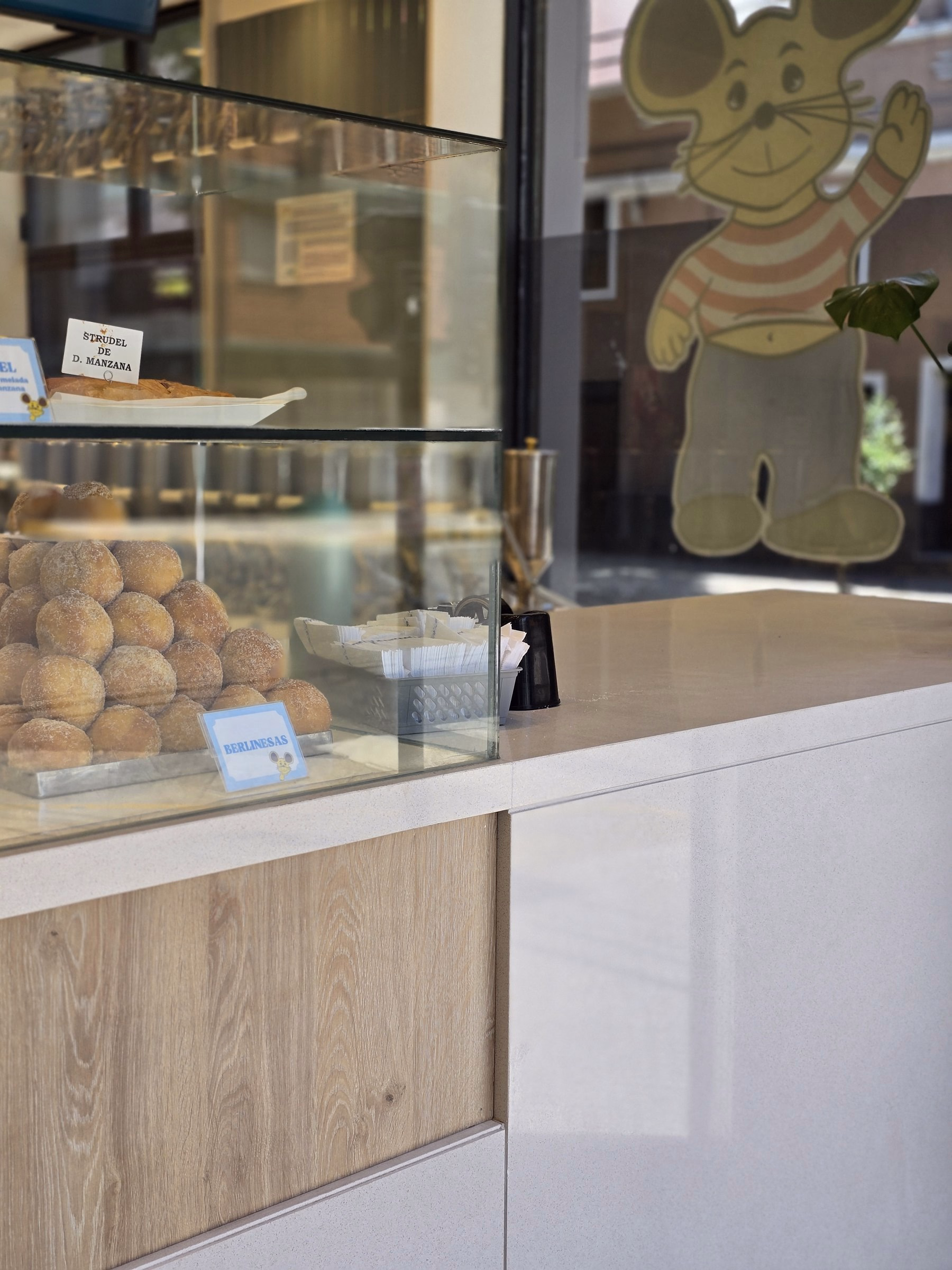 Detalle de la vitrina de El Topo I: churros, vidrio y mesada clara junto a la vidriera